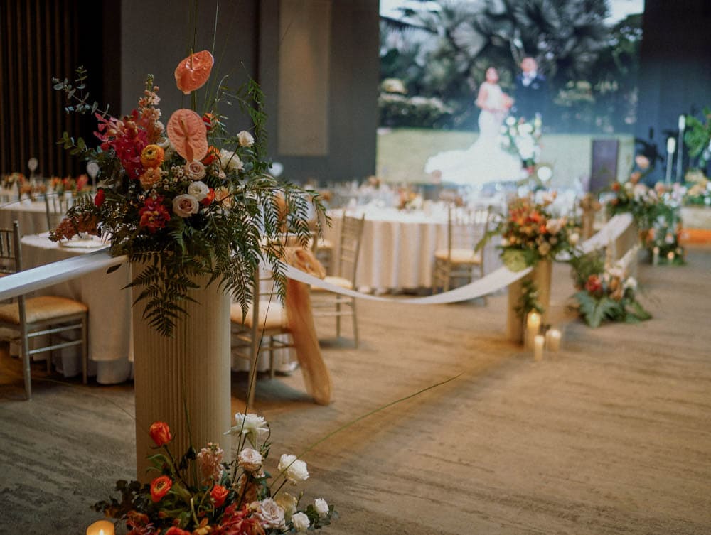 Pedestal floral stand at the aisle with tropical arrangements at Capella Hotel Singapore.