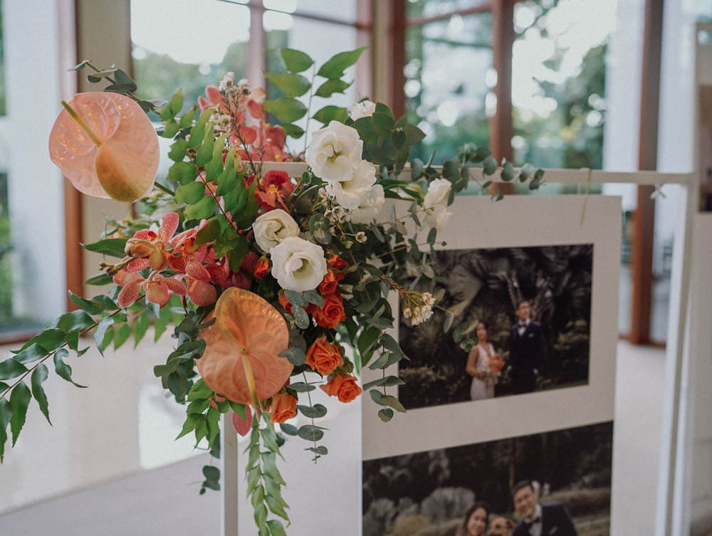 Close-up of warm-toned welcome florals for wedding entrance at Capella Hotel Singapore.