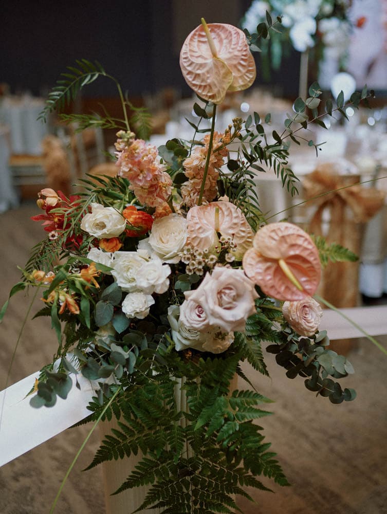 Close up shot of warm tones tropical arrangement on pedestal at Capella Hotel Singapore.