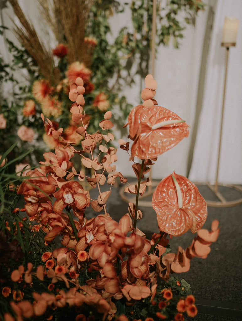 Close up of terracotta roses, anthuriums and dried elements mixed with greenery in warm tone wedding styling at Four Seasons Hotel Singapore