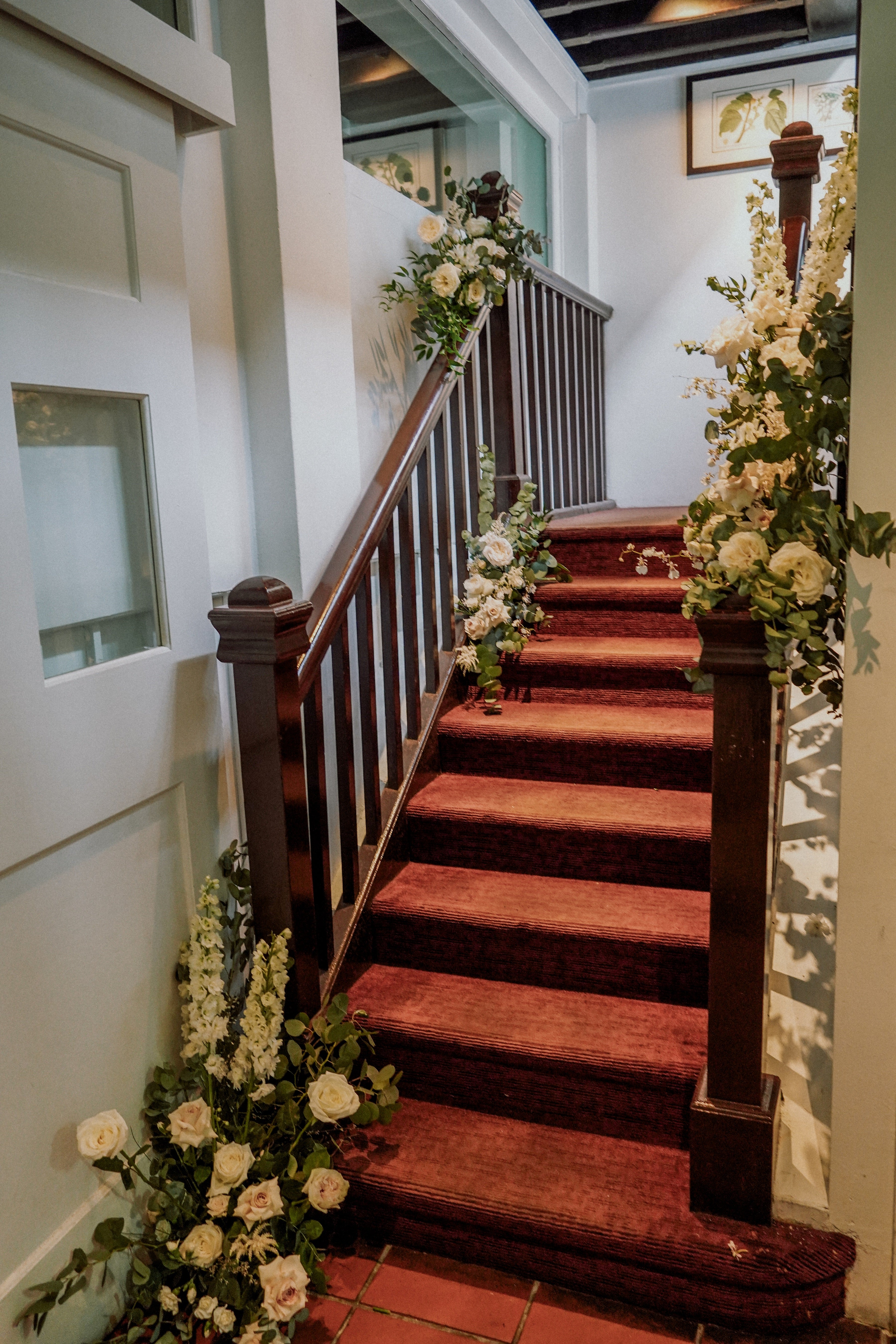 Flower decor setting idea for restaurant wedding staircase photography with white and green theme at Corner House Singapore