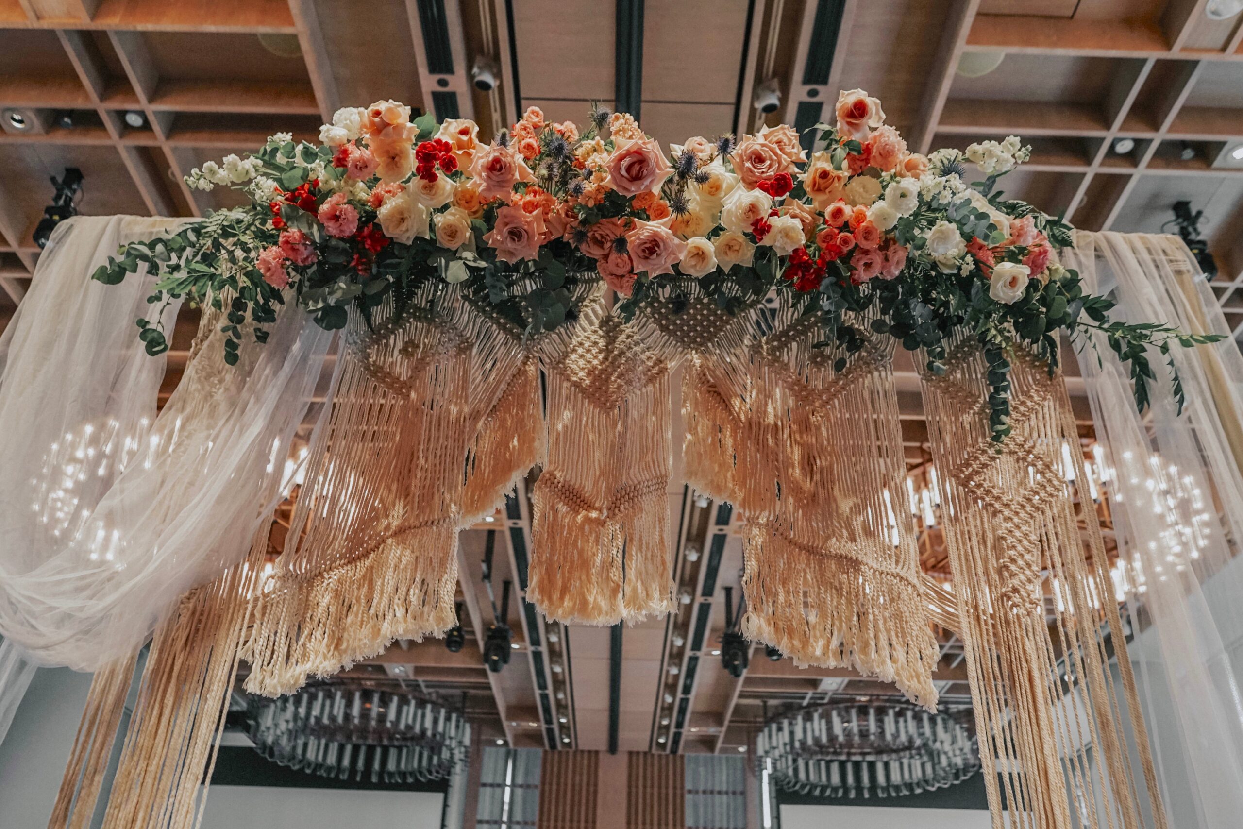 Aisle entrance at Andaz Hotel of macramé with coral roses and peonies floral arrangement