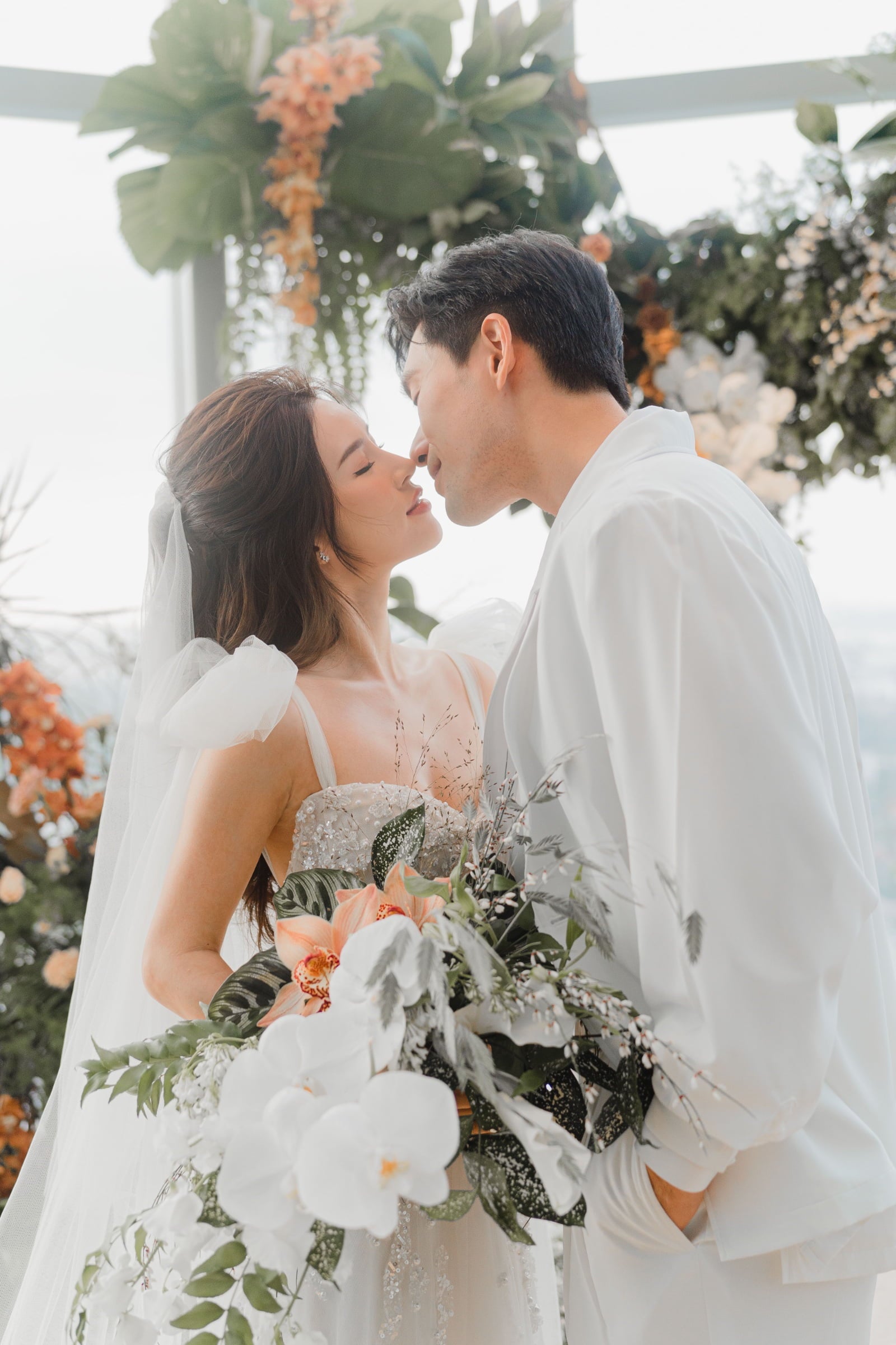 Singapore brides Nicole Chang Min at wedding venue with James Seah actor posing for a kiss