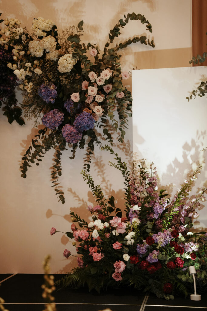  Overhead floral design featuring soft roses, white snapdragons, and violet delphiniums.