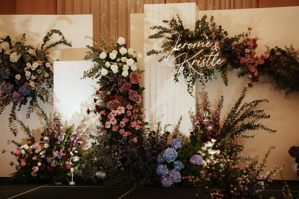 Purple theme romantic floral display over white panel with warm tones and garden greenery.