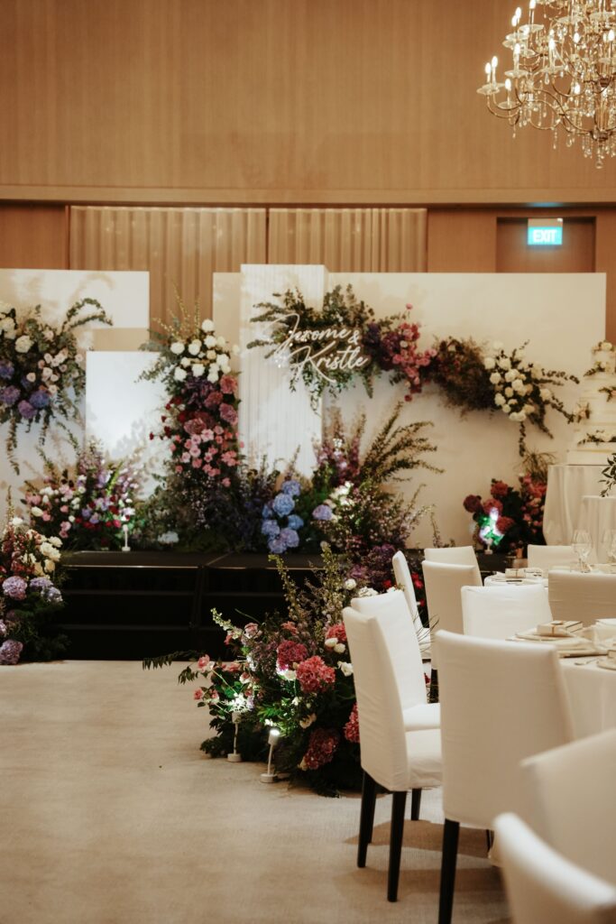 Florals lining the aisle at Edition Hotel Singapore with soft white, violet and purple theme.