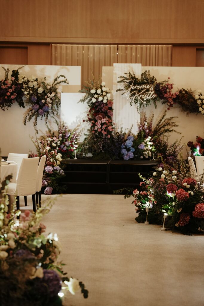 Aisle shot with purple bold romantic blooms leading to the ceremony backdrop.