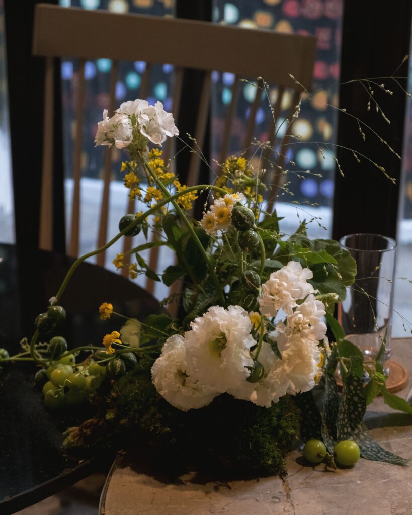 Rustic floral styling featuring white carnation and moss at Open Farm Community.