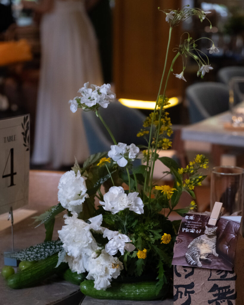 A soft side angle showing the guest with the nature-inspired floral tablescape during the celebration.