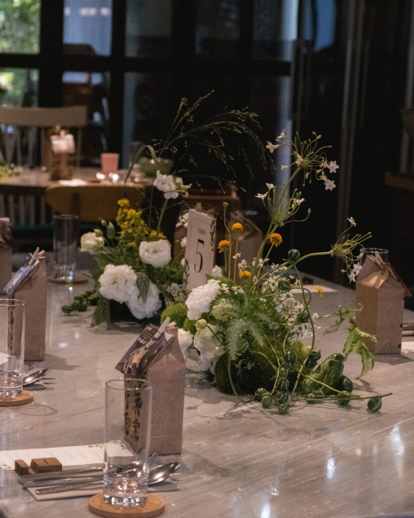 Full table styling with unique white florals and handcrafted decor items for a wedding reseption.