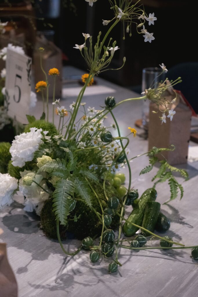 Fresh garden-inspired tablescape with long styling and vines for a wedding on cool tone table.