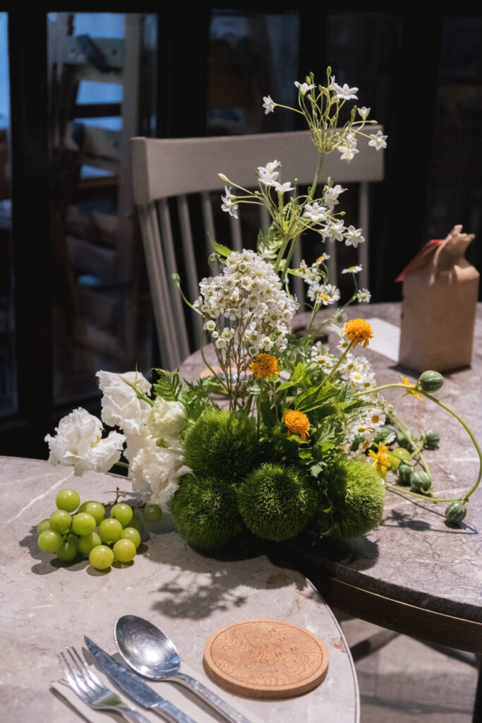Green grapes and white florals styled as part of a low eco-luxe centerpiece.