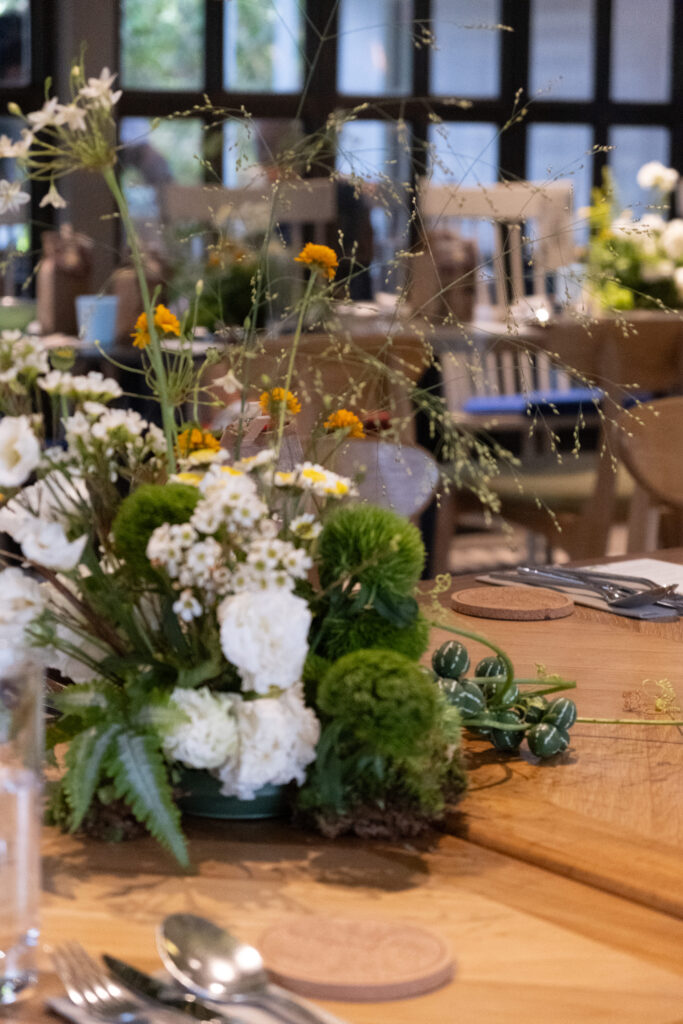 Floral styling with yellow accents, white flowers and moss at Open Farm Community Singapore