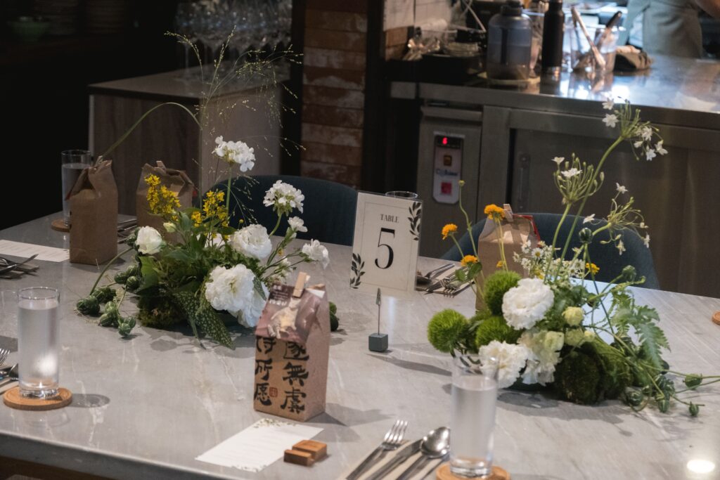 Floral tablescape with intentional negative space between arrangements, allowing breathing room and focus on each centerpiece.