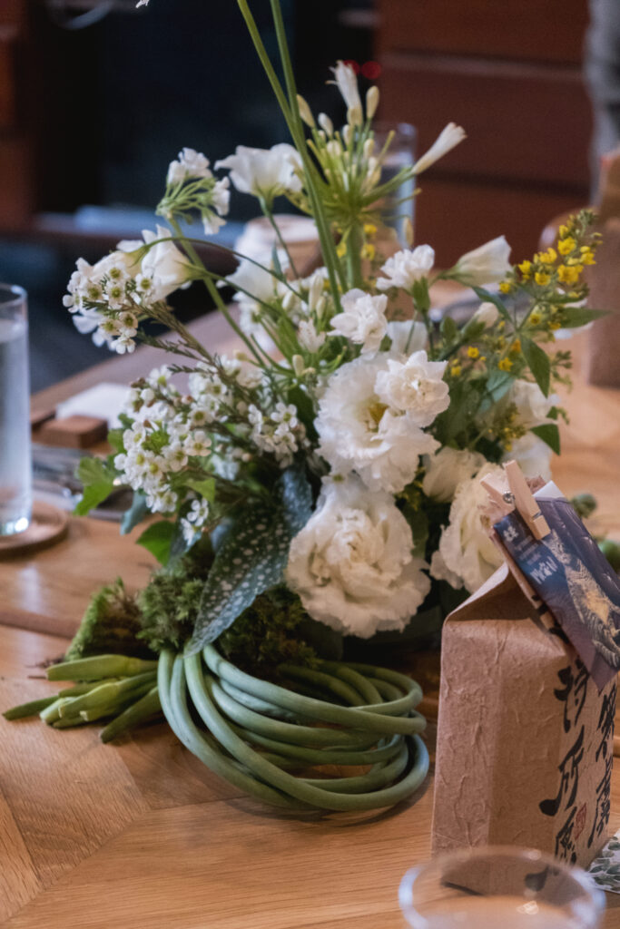 Whimsical floral tablescape with carnations and soft petals in a twisted base at Open Farm Community.