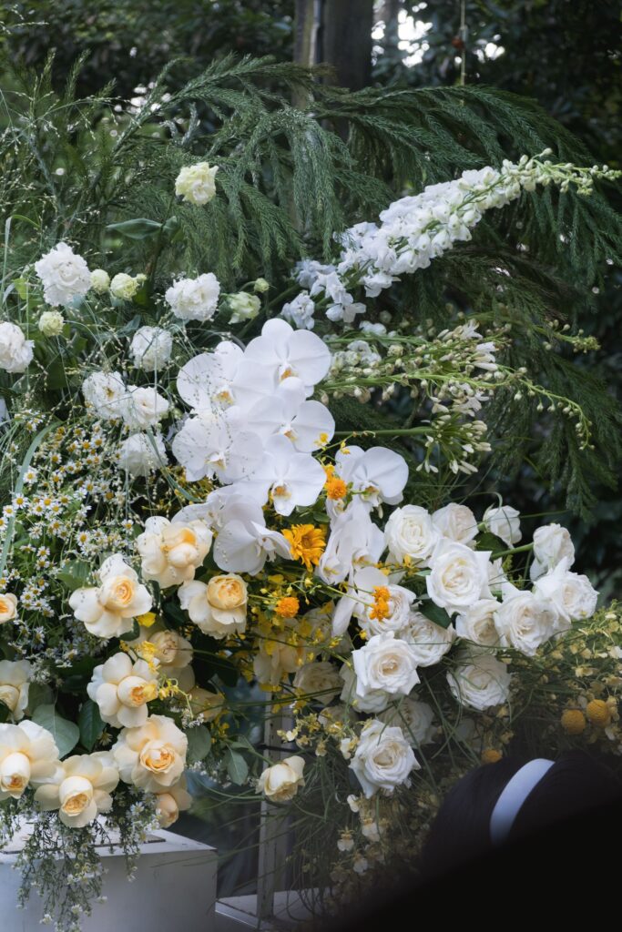 Backdrop floral installation with cascading white orchids and yellow accents for solemnization 