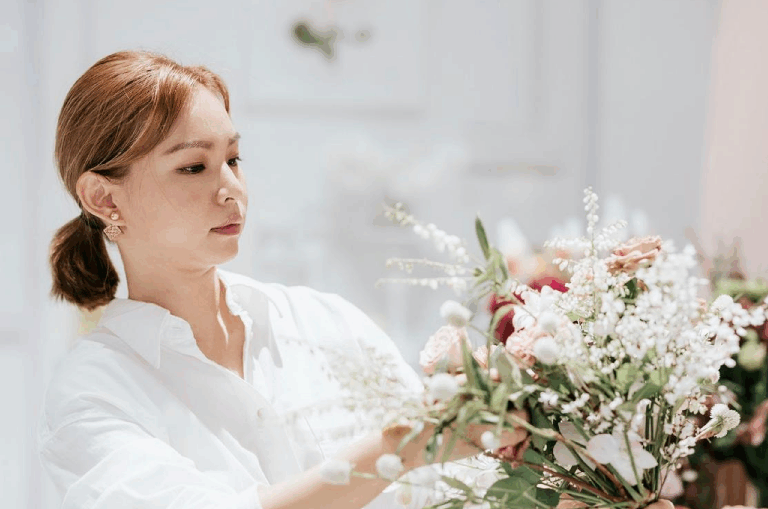 Bucket Full of Roses Founder, Kayly, holding soft-toned bouquet.