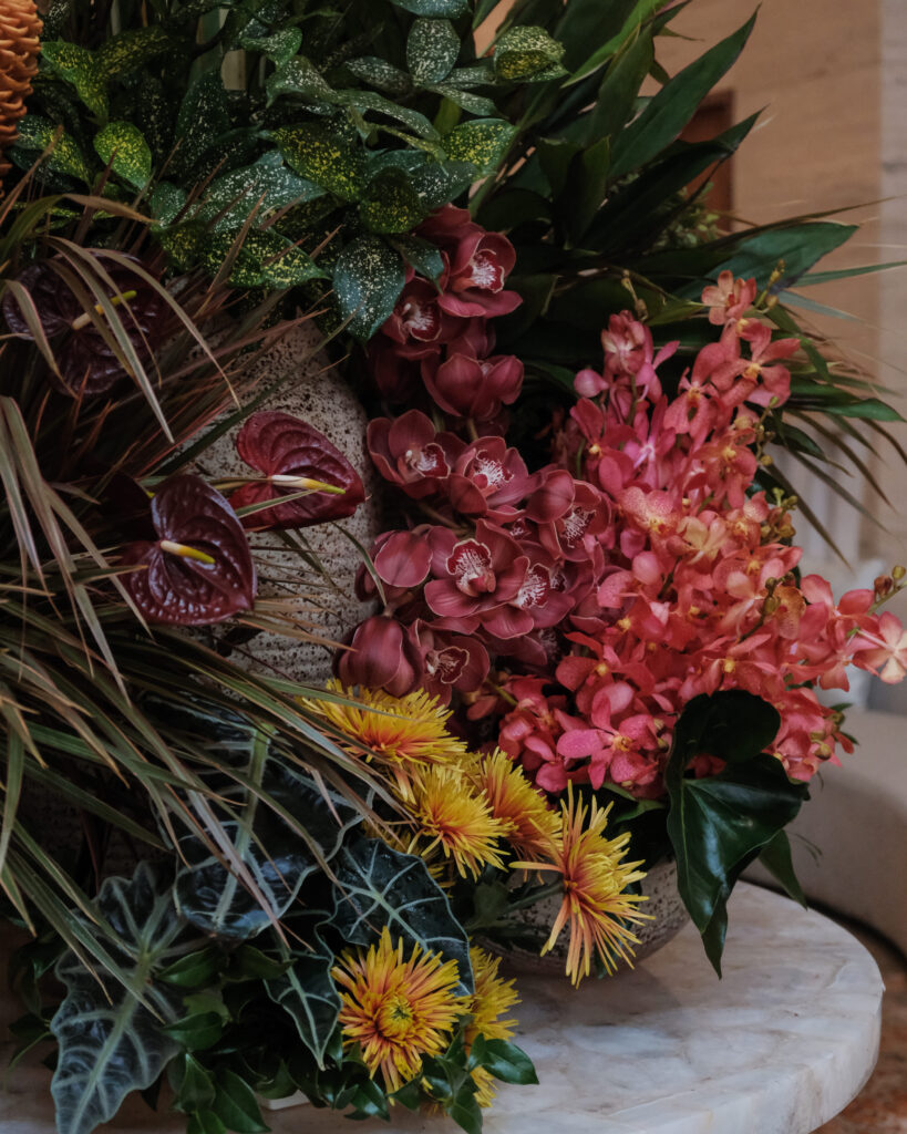 Bold mix of yellow, red, and green foliage creating impactful corporate event styling.