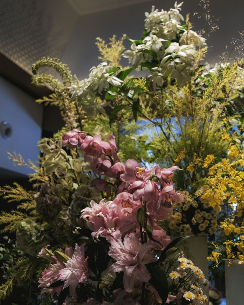 Tall arrangement of pink and yellow florals styled for corporate events in Singapore at Hotel Michael.