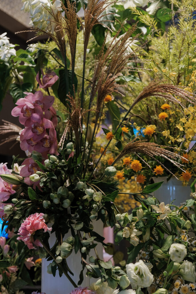 Close up arrangement with pink cymbidiums and yellow oncidiums styled for hotel lobby events.