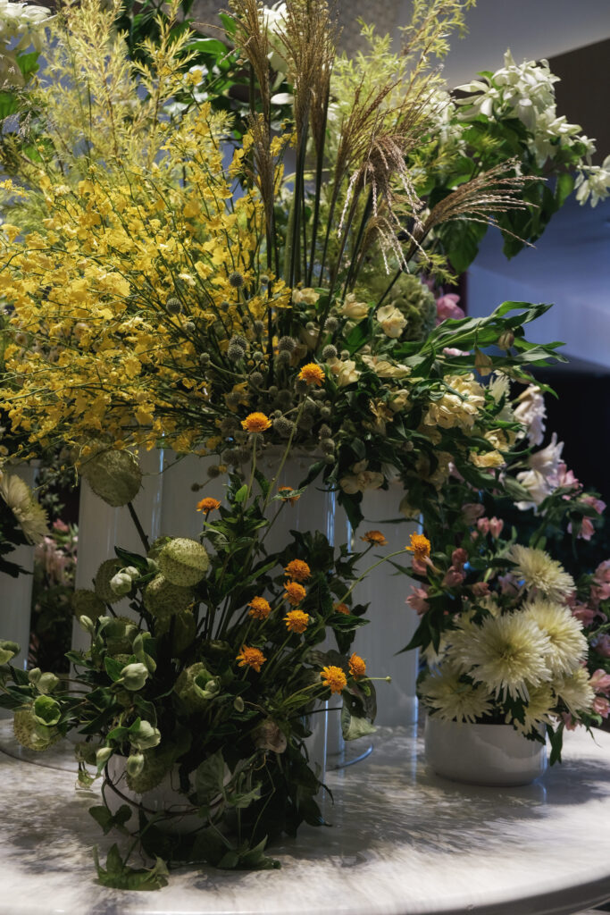 Garden style floral centerpiece with mixed pastels and greens enhancing Hotel Michael’s entrance.