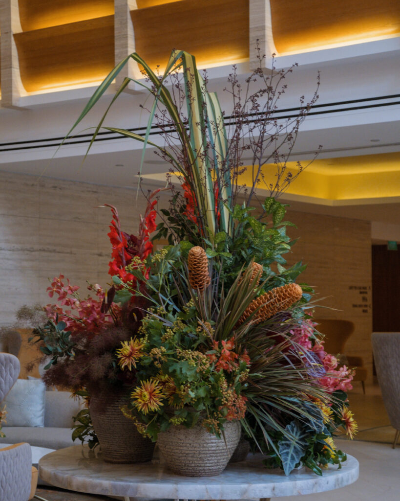 Dramatic tropical display with branches and orange blooms creating visual impact at Hotel Michael.