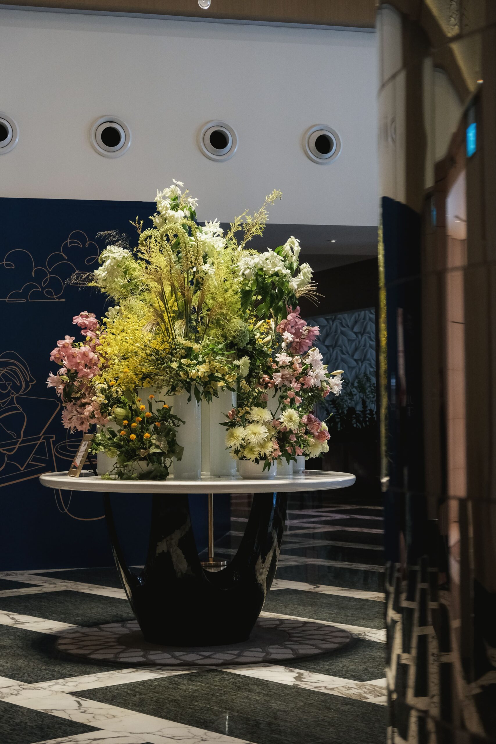 Full view of pastel and yellow floral arrangement welcoming guests at Hotel Michael lobby, Resorts World Sentosa.