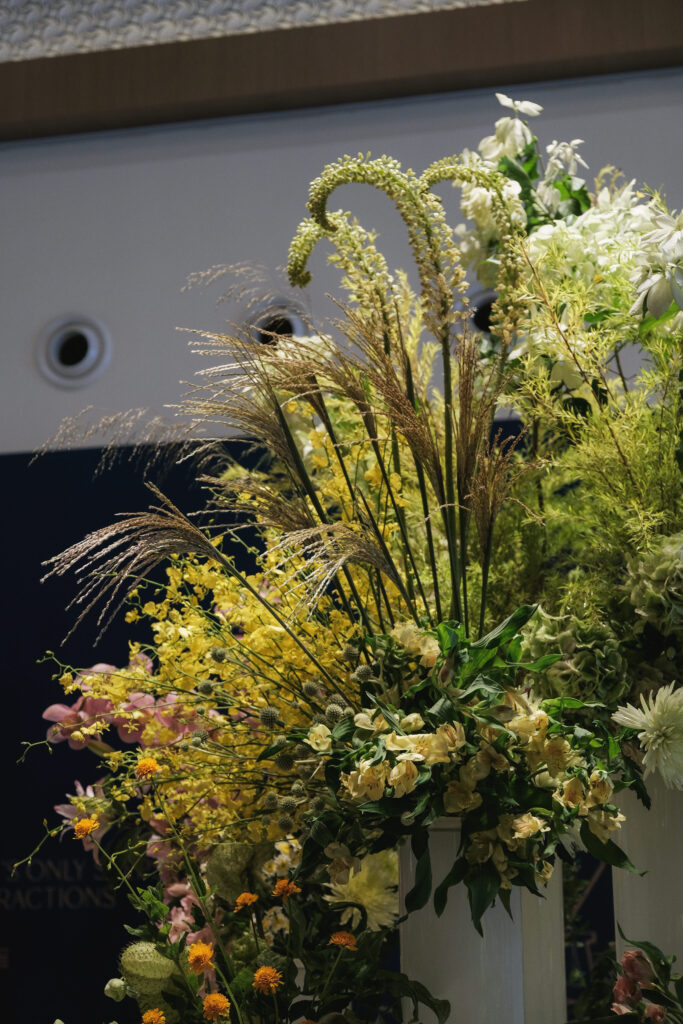 Soft mix of yellow, pink, and green foliage creating impactful corporate event styling.
