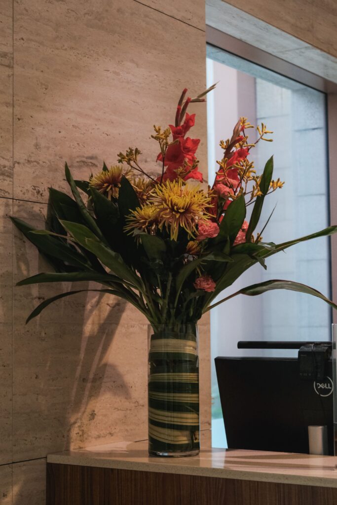 Colorful bold tropical greens in a vase with unique textures styled for corporate events at Hotel Michael.