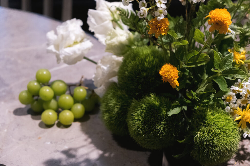 Close-up of table flowers with green grapes at Open Farm Community
