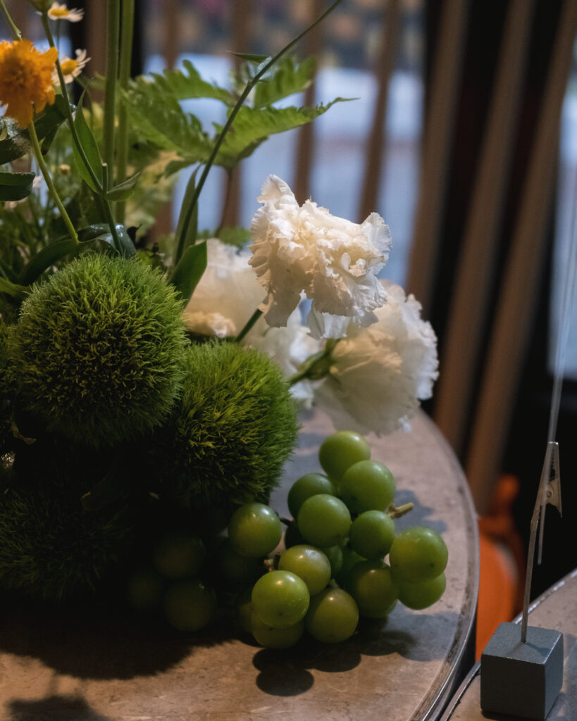 Close-up of table flowers with green grapes at Open Farm Community