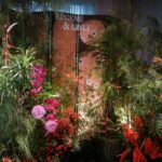 Tropical rainforest style foyer backdrop with orchids, anthuriums, willow branches, and cultural Peranakan accents at Four Seasons Singapore