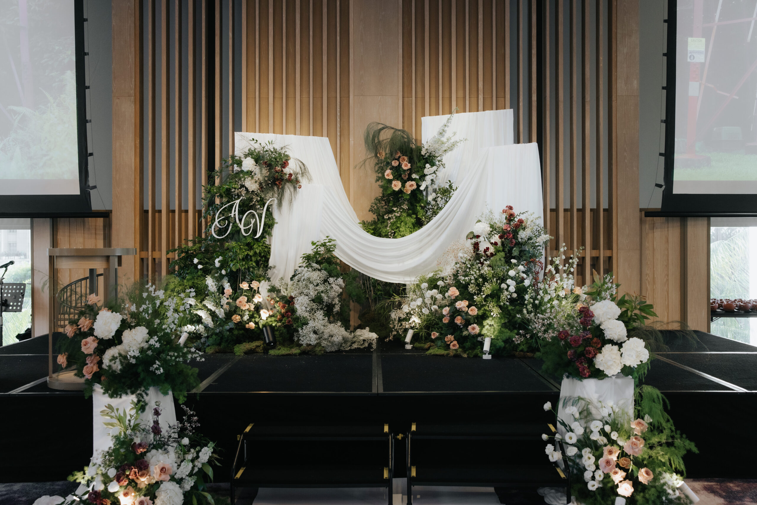 Organic antique garden wedding stage with flowing drapes and layered wild florals in white brown green palette at Andaz Singapore