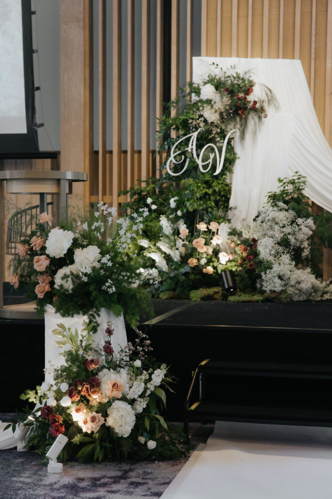 Wedding stage steps styled with cascading florals and soft drapery extension at Andaz Singapore