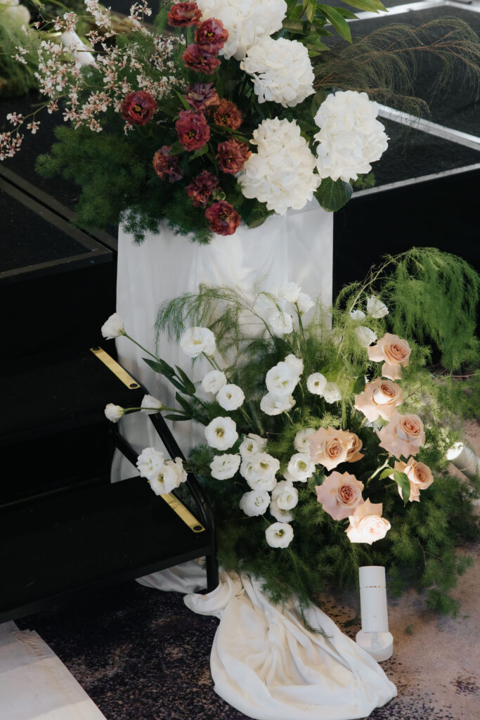 Detailed view of pedestal floral arrangement on stage steps with wild organic flowers at Andaz Singapore
