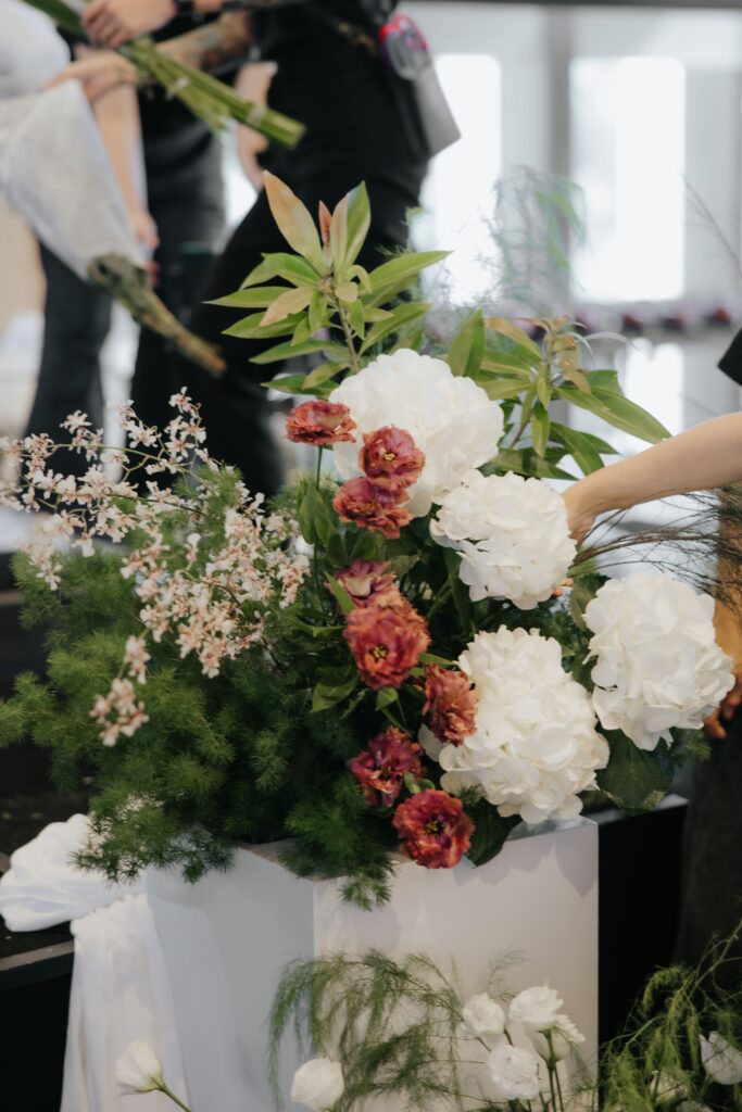 Floral arrangement on pedestal for stage steps incorporating soft drapes and organic greenery at Andaz Singapore