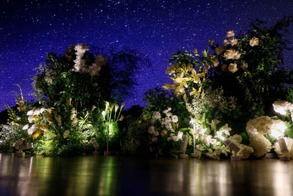 Low and lush stage floral landscape with greenery against a starry LED backdrop at Capella Hotel Singapore