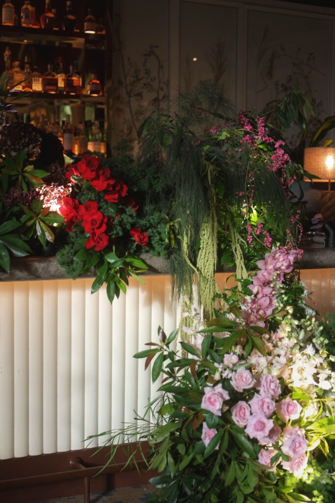 Modern botanical bar installation with red roses, blush roses and lush greenery creating a focal point for the VIP table, Claudine Singapore
