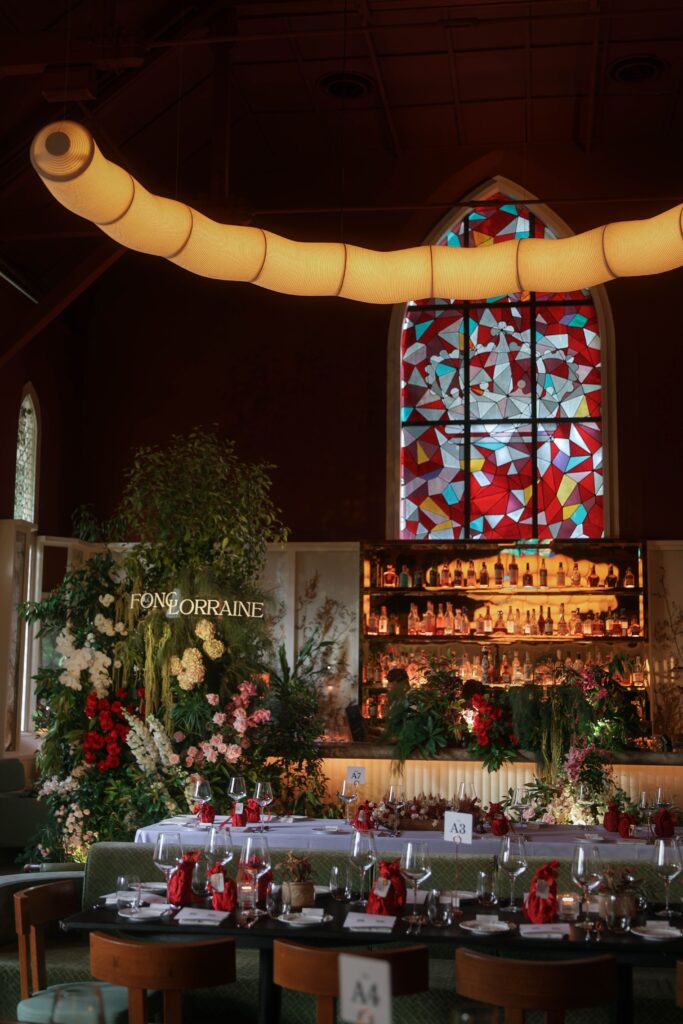 Overview of intimate wedding dinner setup with botanical bar installation and modern floral styling in white, pink and red tones, Claudine Singapore