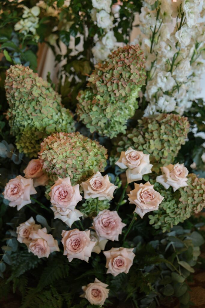 Aisle floral arrangement with pastel roses, hydrangeas and layered foliage in a soft romantic palette at The Ritz-Carlton Singapore