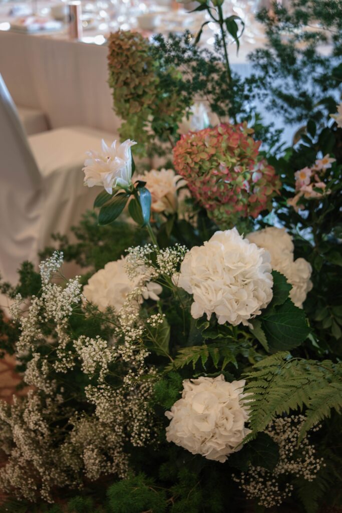 Close-up of romantic ceremony florals featuring white hydrangeas, blush roses and soft greenery in an organic garden style at The Ritz-Carlton Singapore