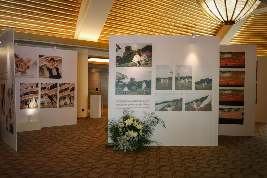 Wedding gallery panels displaying relationship milestones enhanced with blush and white floral arrangements in a garden style at The Ritz-Carlton Singapore