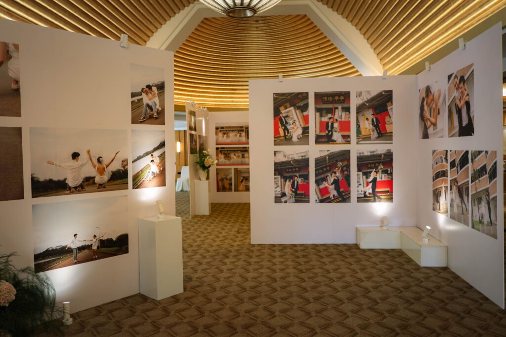 Immersive foyer setup featuring structured photo panels and garden-style floral accents guiding guests through a wedding memory lane at The Ritz-Carlton Singapore