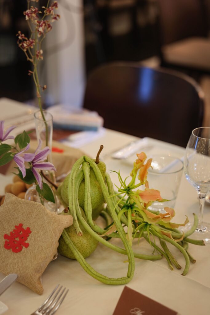 Organic wedding table detail with long beans, grapes, apples, and soft florals at The Summerhouse Restaurant Singapore