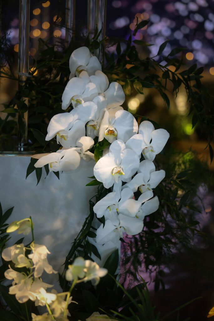 Cascading white Phalaenopsis orchid floral arrangement with soft greenery accents styled for candlelight wedding decoration at JW Marriott Hotel Singapore