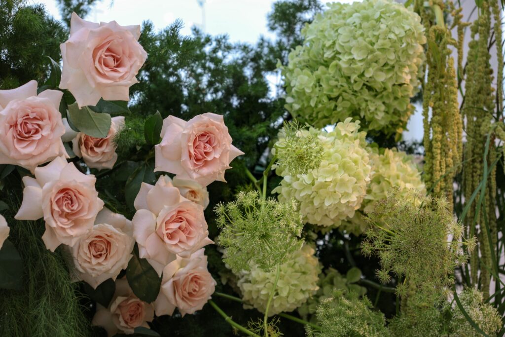 Close-up of blush roses, hydrangeas, and soft garden greenery styled as part of the floral ceremony installation at Sky Garden Sentosa, Sentosa Singapore