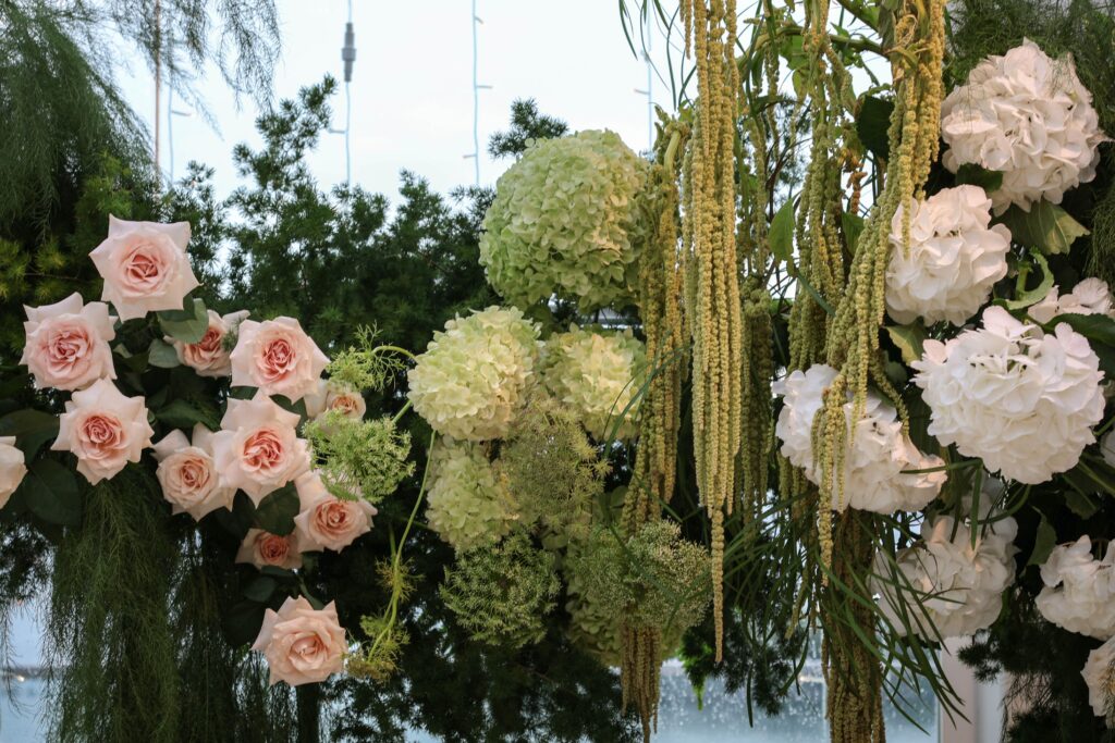 Close-up detail of wedding arch flowers featuring blush roses, white hydrangeas, cascading amaranthus and textured greenery arranged in a natural garden style at Sky Garden Sentosa, Sentosa Singapore