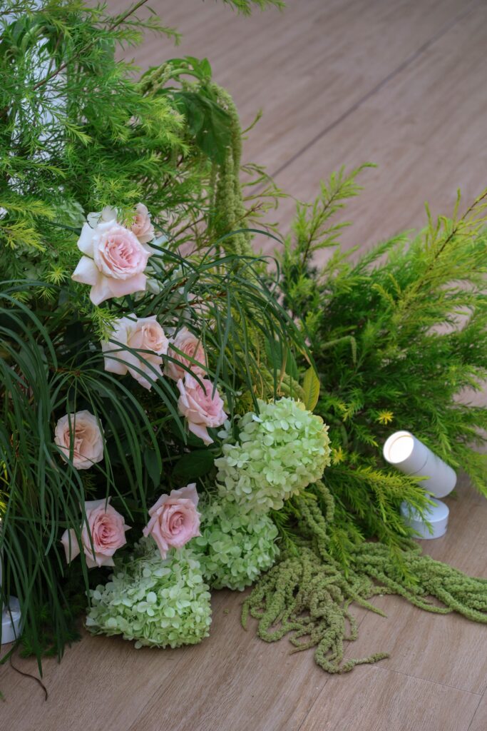 Close-up detail of wedding arch flowers featuring blush roses, green hydrangeas, amaranthus, and textured greenery arranged in a natural garden style at Sky Garden Sentosa, Sentosa Singapore