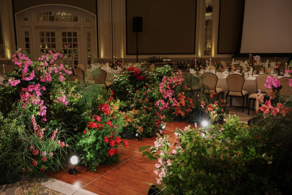 Fully surrounded dance floor with lush English garden floral styling using roses, bougainvillea tones, and layered greenery creating an immersive setting at Raffles Hotel Singapore