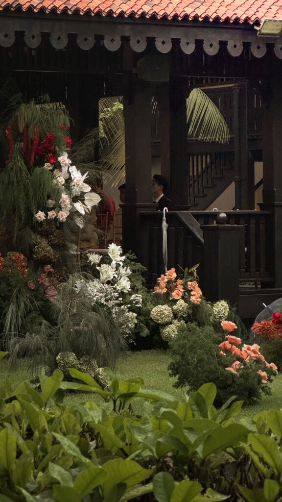 Asymmetrical modern classic floral installation with white hydrangeas, blush roses, maroon accents, and soft greenery styled beside the pavilion for a colonial wedding ceremony at Raffles Hotel Singapore